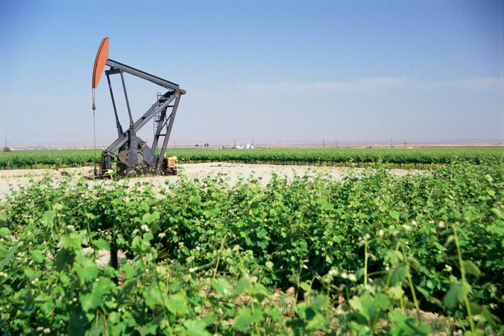 An oil well pumpjack in a green field