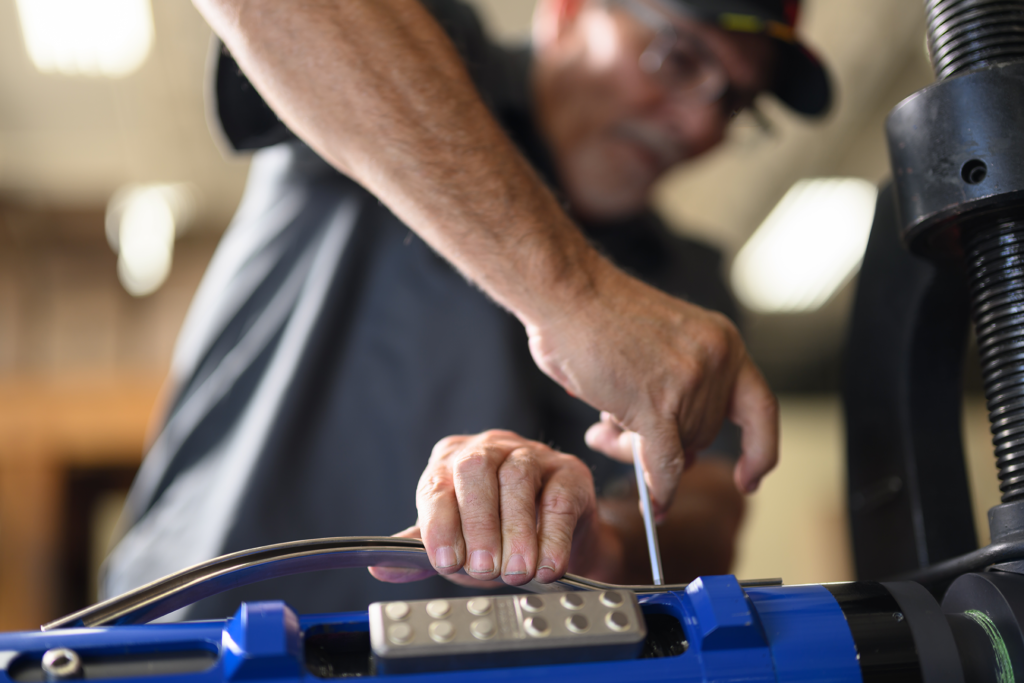 A TechTAC employee tightens a screw on a Slimline Tubing Anchor Catcher