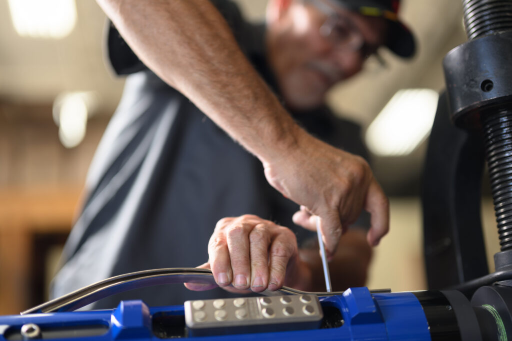 A TechTAC employee tightens a screw in a Slimline Tubing Anchor Catcher