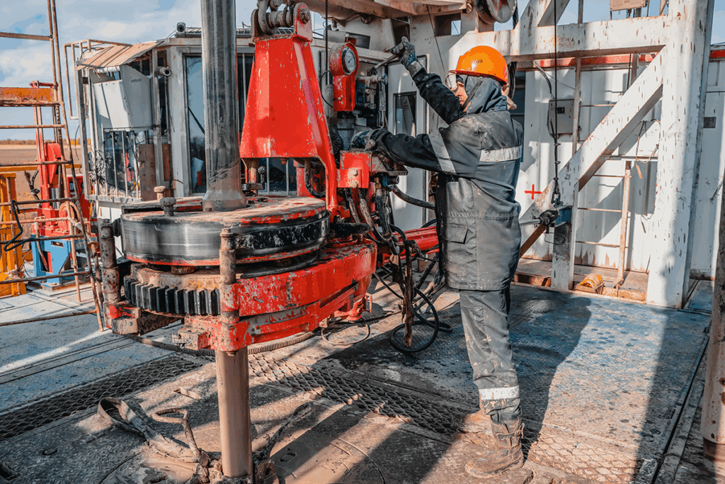 Oil workers operating power tongs