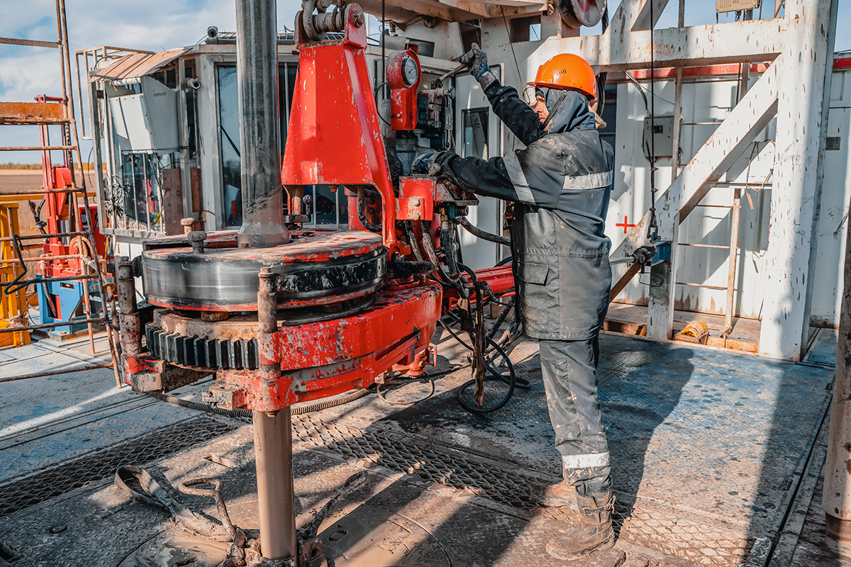 Oil workers operating power tongs
