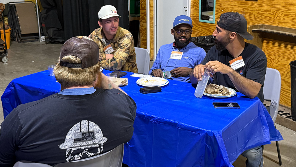 A group of men talking at a TechTAC event