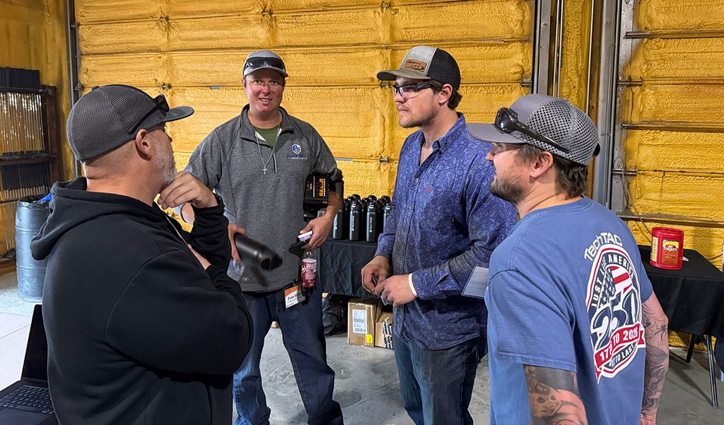 A group of four men talking at a TechTAC event